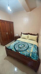 a bedroom with a bed with a blue and white comforter at MRIRT Home N4 in Jemaa de Mrirt