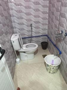 a bathroom with a toilet and a bucket in it at MRIRT Home N4 in Jemaa de Mrirt