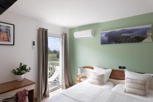 a bedroom with a white bed and a large window at Hôtel Maristella in Algajola +66 photos