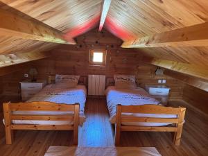 a room with two beds in a log cabin at " domaine des chevrettes chalet cosy au cœur des châteaux " in Cour-Cheverny