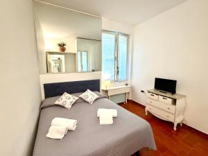 a bedroom with a bed with a mirror on the wall at Excelsior Relaxing Apartment in Levanto