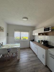 a kitchen with a table and a table and chairs at Apartma Laganini in Bosiljevo