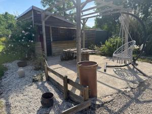 a garden with a wooden fence and a barrel at " domaine des chevrettes chalet cosy au cœur des châteaux " in Cour-Cheverny +10 photos