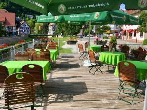 a group of tables and chairs with green umbrellas at Zur alten Brücke in Schiltach