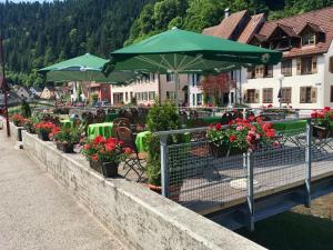 a restaurant with flowers and umbrellas on a bridge at Zur alten Brücke in Schiltach