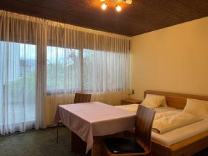 a bedroom with a bed and a table and a window at Hotel Garni Vindobona in Pörtschach am Wörthersee