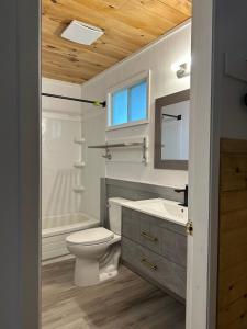 a bathroom with a toilet and a sink and a tub at Greenside Motel in Saint Andrews +82 photos
