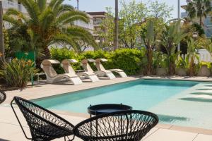 a swimming pool with chairs next to a building at Instants Boutique Hotel in Cambrils