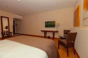 a bedroom with a bed and a desk and a table at Vila Galé Paulista in São Paulo