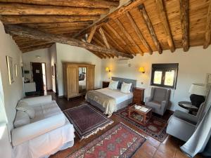 a bedroom with a bed and a couch and a chair at La Guzmana de Ronda in Ronda +99 photos
