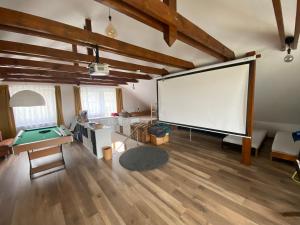 a large screen in a room with a pool table at Aura Vendégház in Révfülöp