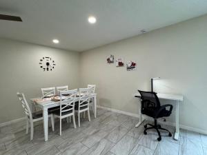 a dining room with a white table and chairs at Sunshine Nest in Lehigh Acres