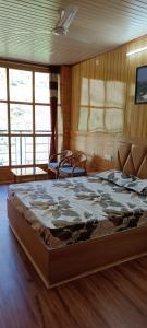 a bedroom with a large bed in a room at Apple Bud Homestay in Ghund