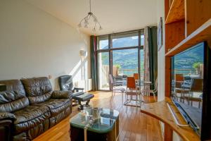 a living room with a couch and a table at Feet in the water! in Duingt