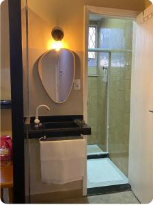 a bathroom with a shower with a sink and a mirror at Loft Campinho 2 in Estação Inhoaíba