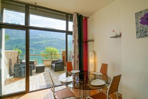a dining room with a glass table and a large window at Feet in the water! in Duingt