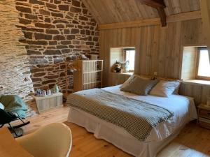 a bedroom with a large bed in a brick wall at Les Bouyeres in Saint-Malon-sur-Mel