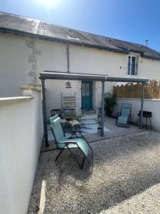 a patio with two chairs and a house at Chat-Douillet in Veuzain-sur-Loire
