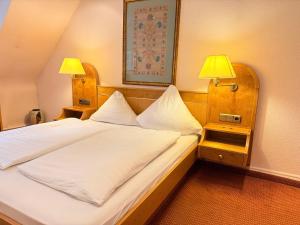 a bedroom with a large bed with two lamps at Zur alten Brücke in Schiltach +13 photos