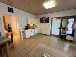 a kitchen with white cabinets and a table in a room at Ferienwohnung Stani in Leibnitz +1 photo