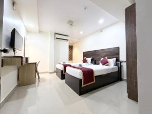 a hotel room with two beds and a television at Malaysia inn in Chennai +66 photos