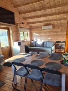 a living room with a table and chairs and a couch at Sodyba 15 Ąžuolų Svečių namai 2 in Triušiai