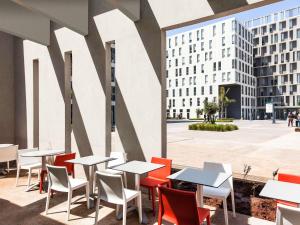 a cafeteria with tables and chairs and a building at Ibis Casanearshore in Casablanca