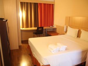 a hotel room with a bed with towels on it at ibis Montes Claros Shopping in Montes Claros