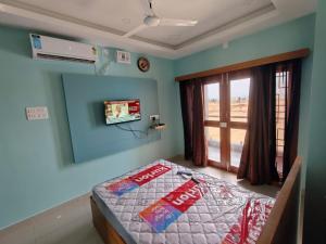 a bedroom with a bed and a tv on the wall at Sathya Bay in Marakkānam +38 photos