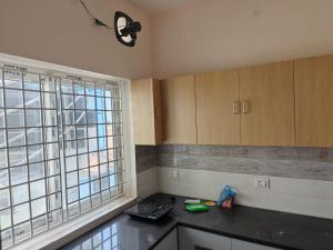 a kitchen with a counter top and two windows at Sathya Bay in Marakkānam
