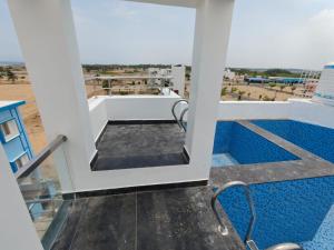 a view from the balcony of a building with a pool at Sathya Bay in Marakkānam
