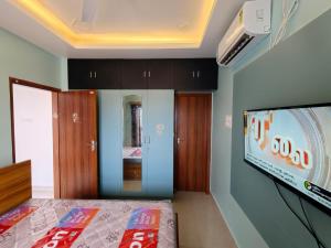 a room with a tv and a bed in a room at Sathya Bay in Marakkānam