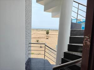 a view of the beach from the stairs of a house at Sathya Bay in Marakkānam