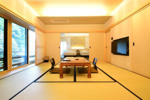 a living room with a table and a tv at Koyasan Shukubo Saizenin in Koyasan