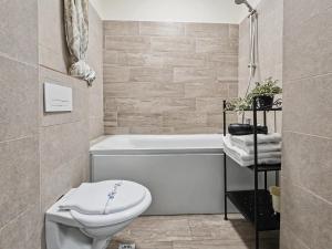 a bathroom with a toilet and a bath tub at Konstanzer 103 - 2 Room Ap & Parking- Iulius Mal - Smart TV - Highspeed Wi-Fi in Iaşi +18 photos