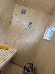 a room with a wooden wall in a tiny house at Maria apartment with Sauna Otta in Otta