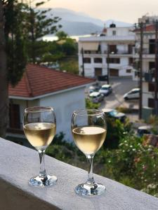 two glasses of white wine sitting on a ledge at Amelie's Stone House in Vathý
