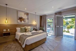 a bedroom with a large bed and a balcony at Arebbusch Travel Lodge in Windhoek