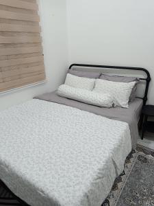 a bed in a bedroom with a white wall at D'Berang Rumah Singgah in Kuala Berang