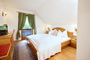 ein Schlafzimmer mit einem weißen Bett und einem Fenster in der Unterkunft Esterer in Grödig