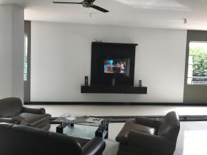 a living room with couches and a tv on a wall at Hotel Baos in Sincelejo