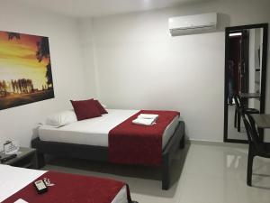 a bedroom with a bed and a chair in it at Hotel Baos in Sincelejo +11 photos