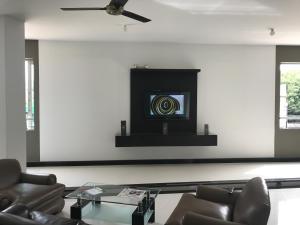 a living room with chairs and a tv on a wall at Hotel Baos in Sincelejo