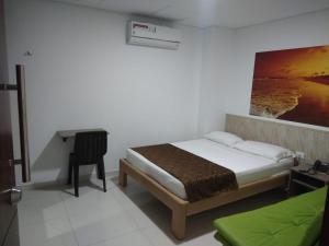 a bedroom with a bed and a desk in it at Hotel Baos in Sincelejo