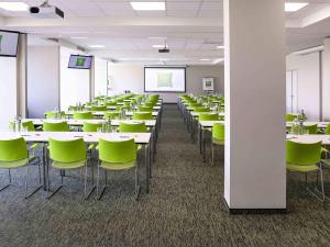 a conference room with tables and green chairs at ibis Styles Zeebrugge in Zeebrugge +154 photos