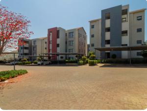 a group of buildings in a parking lot at Luxury Sunset Gem with Power Backup in Sandton
