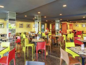 a restaurant with tables and colorful chairs and tablesktop at ibis Styles Chiang Mai in Chiang Mai