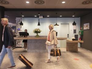 a couple of people walking through a lobby at ibis De Panne in De Panne