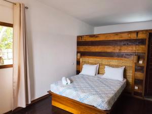 ein Schlafzimmer mit einem Bett mit hölzernem Kopfteil in der Unterkunft Vila Anambo in Monteforte