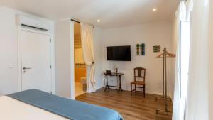 ein Schlafzimmer mit Bett und Flachbildfernseher in der Unterkunft Villa Alter in Alter do Chão
